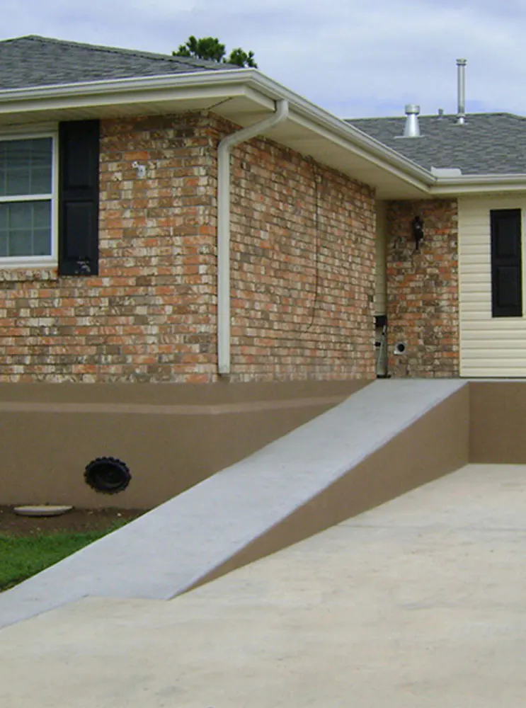 Brick home exterior with a front walkway and foundation vents